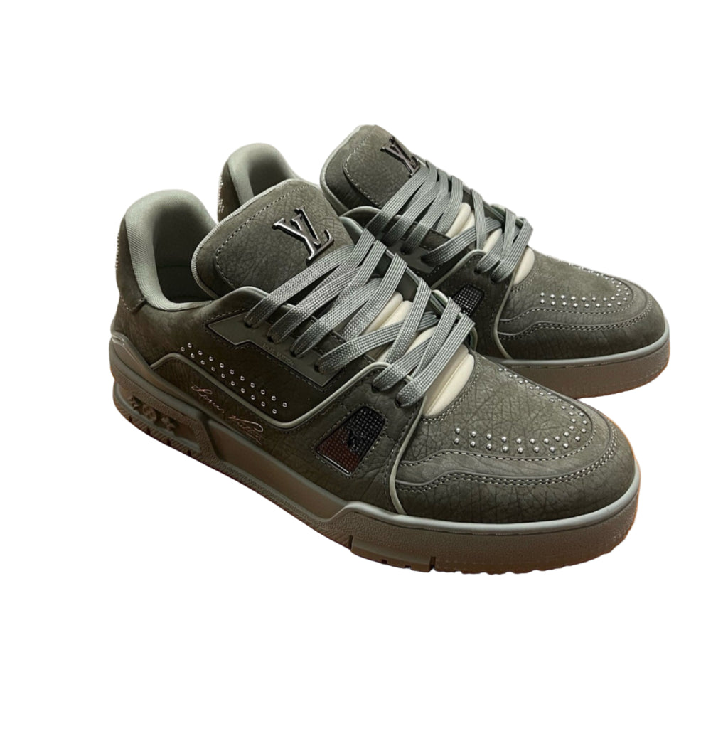 Green sneakers on an orange box with stacked shoe boxes in the background