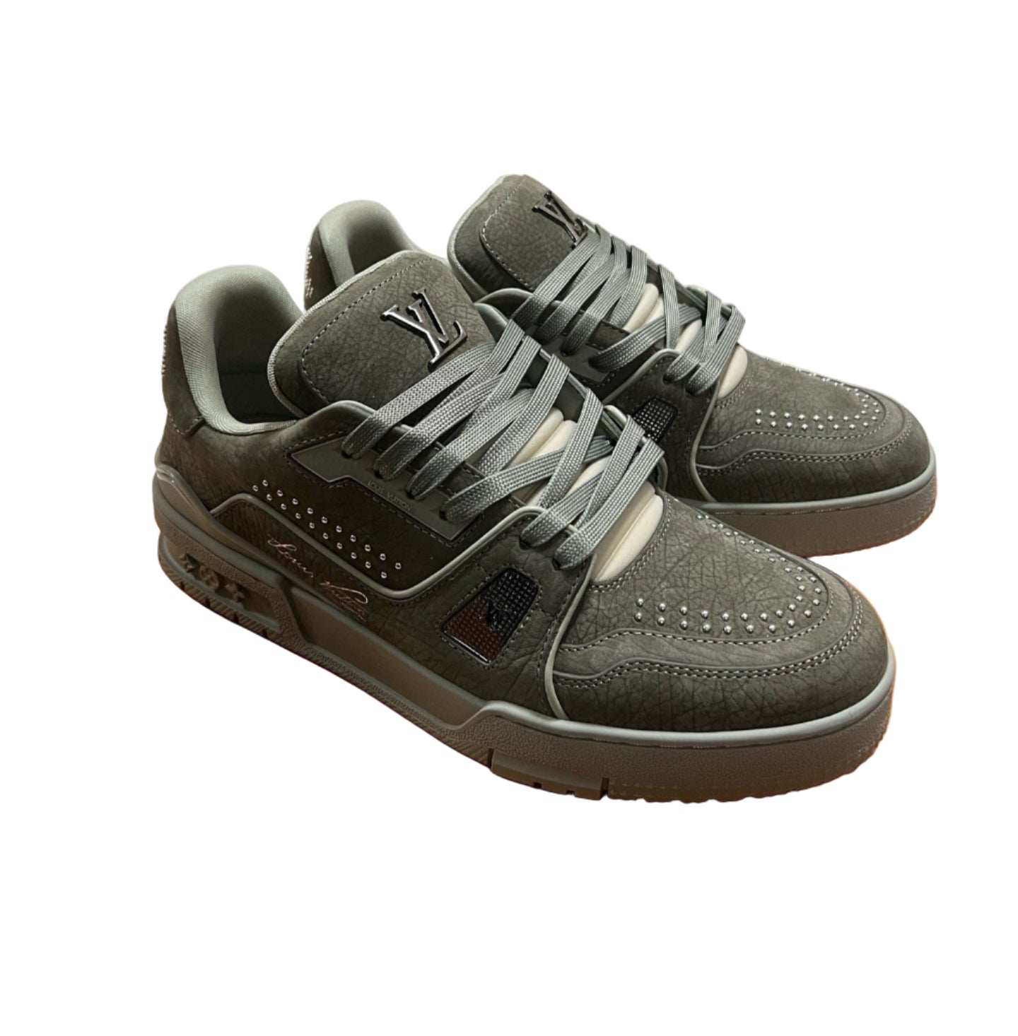 Green sneakers on an orange box with stacked shoe boxes in the background